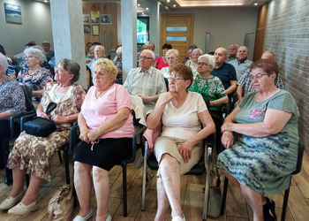 zdjęcie przedstawia grupę Seniorów słuchających wykładu