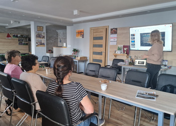 seniorzy oraz osoba prowadząca podczas prelekcji