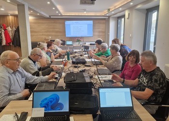 na zdjęciu seniorzy podczas kursu komputerowego 