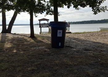 zdjęcie przedstawia kosz na śmieci nad jeziorem