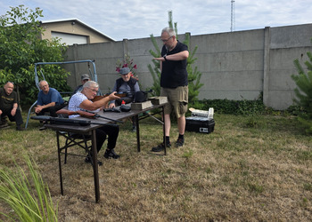 Zdjęcie przedstawia uczestników Klubu Seniora podczas zajęć na strzelnicy